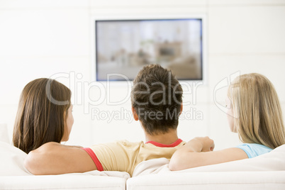 Three friends in living room watching television