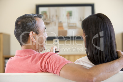 Couple in living room watching television laughing
