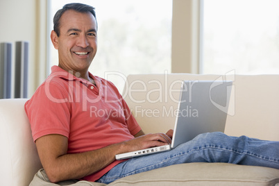 Man in living room using laptop smiling