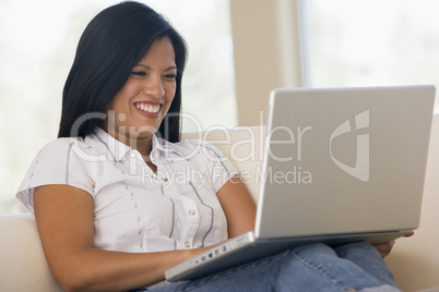 Woman in living room using laptop smiling