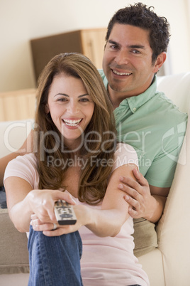 Couple in living room with remote control smiling