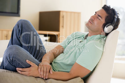 Man in living room listening to headphones sleeping