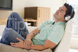 Man in living room listening to headphones sleeping