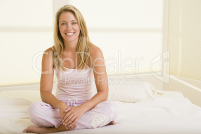 Woman sitting in bedroom smiling