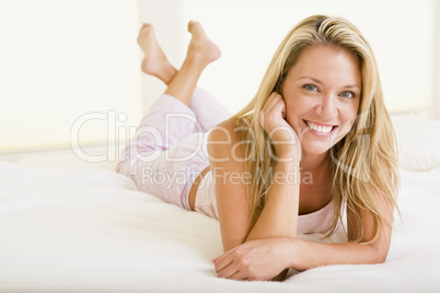 Woman lying in bedroom smiling