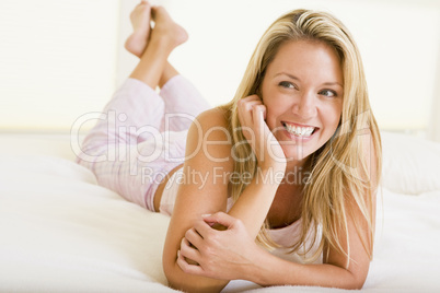 Woman lying in bedroom smiling