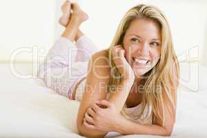 Woman lying in bedroom smiling
