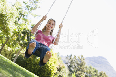 Woman on tree swing smiling