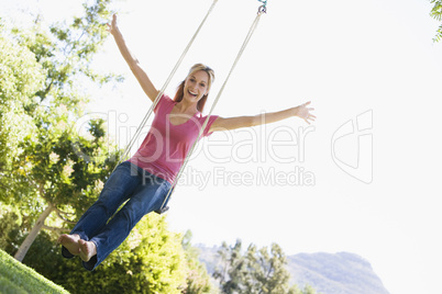 Woman on tree swing smiling