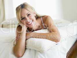 Woman lying in bedroom smiling