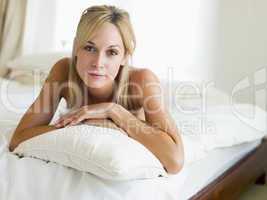 Woman lying in bedroom smiling