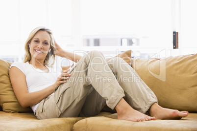 Woman in living room listening to MP3 player smiling