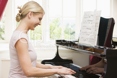 Woman playing piano and smiling