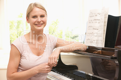 Woman sitting at piano and smiling