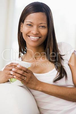 Woman in living room with coffee smiling