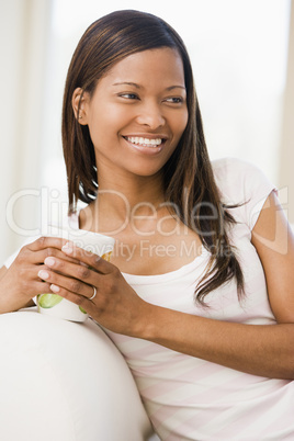 Woman in living room with coffee smiling