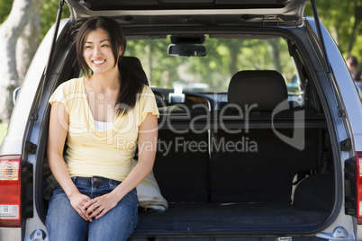 Woman sitting in back of van smiling