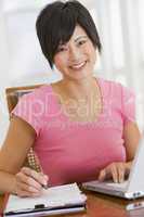 Woman in dining room with laptop smiling