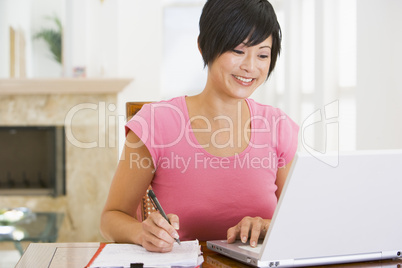 Woman in dining room with laptop smiling