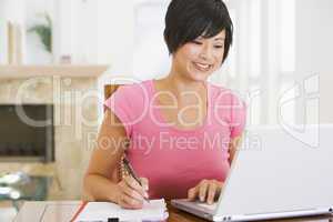 Woman in dining room with laptop smiling