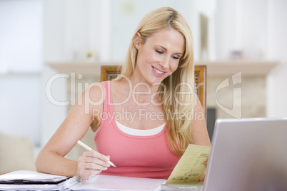 Woman in dining room with laptop smiling