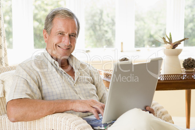 Man in living room with laptop smiling