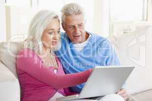 Couple in living room with laptop smiling