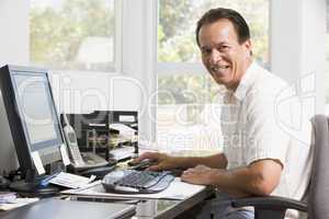 Man in home office at computer smiling