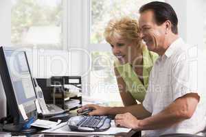 Couple in home office at computer smiling