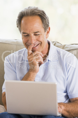 Man in living room with laptop smiling