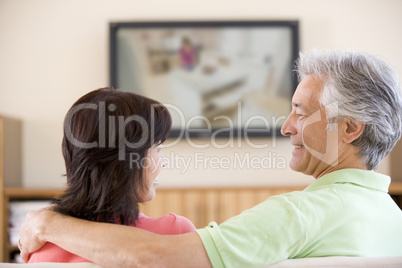 Couple watching television smiling