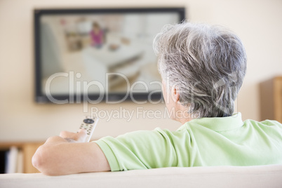 Man watching television using remote control