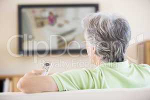 Man watching television using remote control