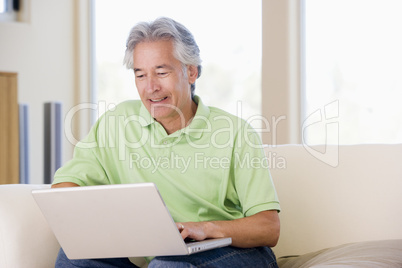 Man in living room with laptop smiling