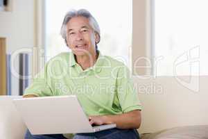 Man in living room with laptop smiling