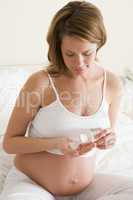 Pregnant woman in bedroom with medicine