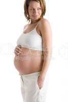 Pregnant woman holding exposed belly smiling