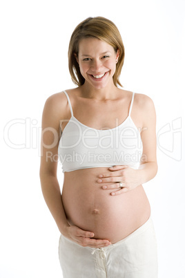 Pregnant woman holding exposed belly laughing