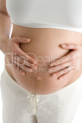 Pregnant woman holding exposed belly