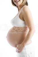 Pregnant woman with exposed belly smiling