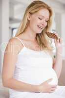 Pregnant woman with chocolate smiling