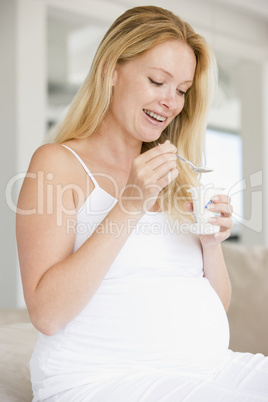 Pregnant woman with yogurt smiling