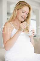 Pregnant woman with yogurt smiling