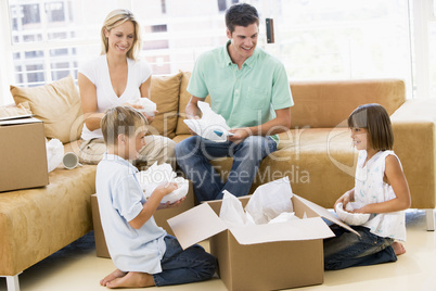 Family unpacking boxes in new home smiling