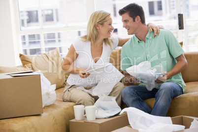 Couple unpacking boxes in new home smiling