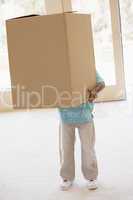Young boy holding box in new home