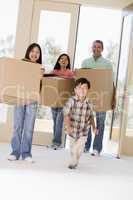 Family with boxes moving into new home smiling