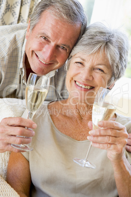 Couple in living room drinking champagne and smiling