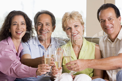 Two couples in living room drinking champagne and smiling