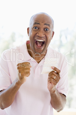 Man with winning lottery ticket excited and smiling